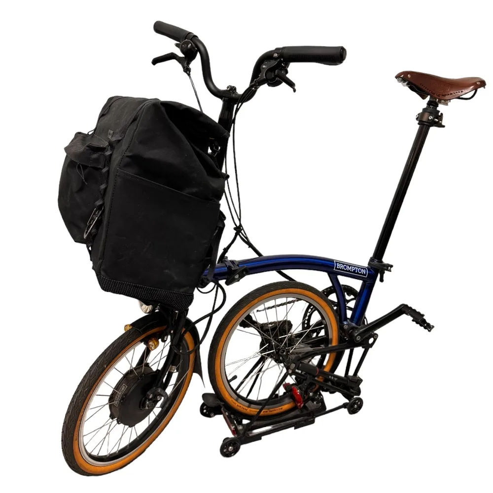 Brom-E in Schwarz am blauen Brompton Electric, Dreiviertelansicht