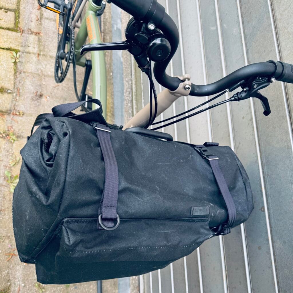 QUER in Schwarz am Brompton von schräg oben: Frontfach, D-Ringe und Halteschlaufen