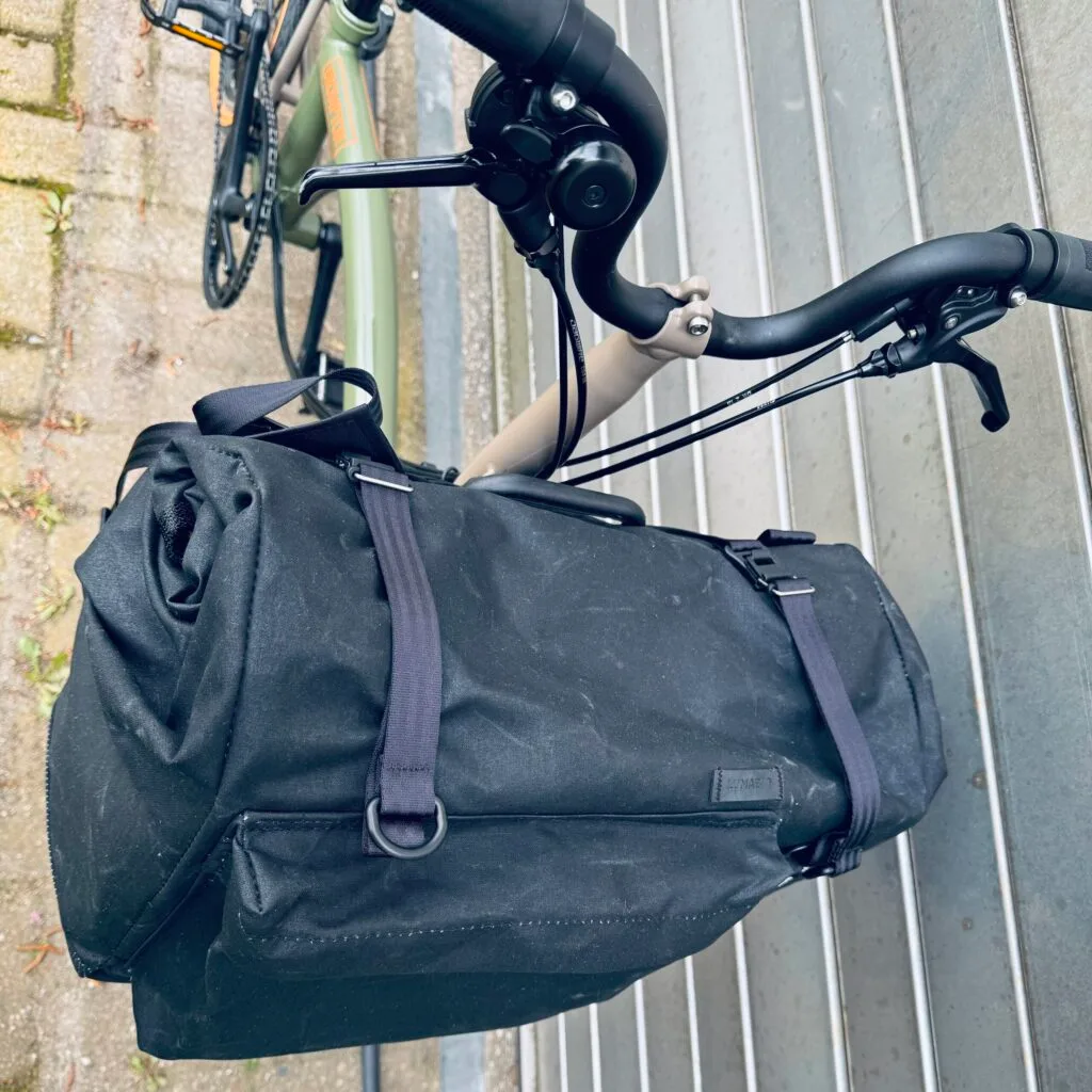 QUER in Schwarz am Brompton von schräg oben: Frontfach, D-Ringe und Halteschlaufen