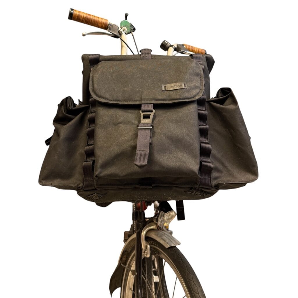 Bromfort in Schwarz von vorn am Rad mit seitlichen Rolltop-Taschen