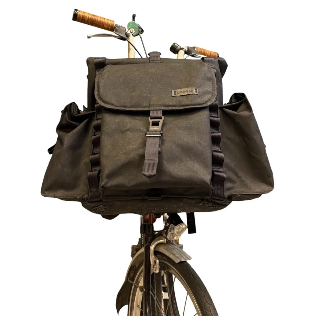 Bromfort in Schwarz von vorn am Rad mit seitlichen Rolltop-Taschen